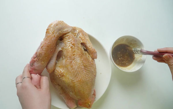 Sử dụng chổi quét dầu để quét nước sốt lên toàn bộ con gà